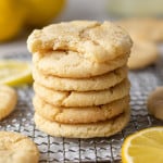 Lemon cookies in stack, the top one with a bite taken out of it.