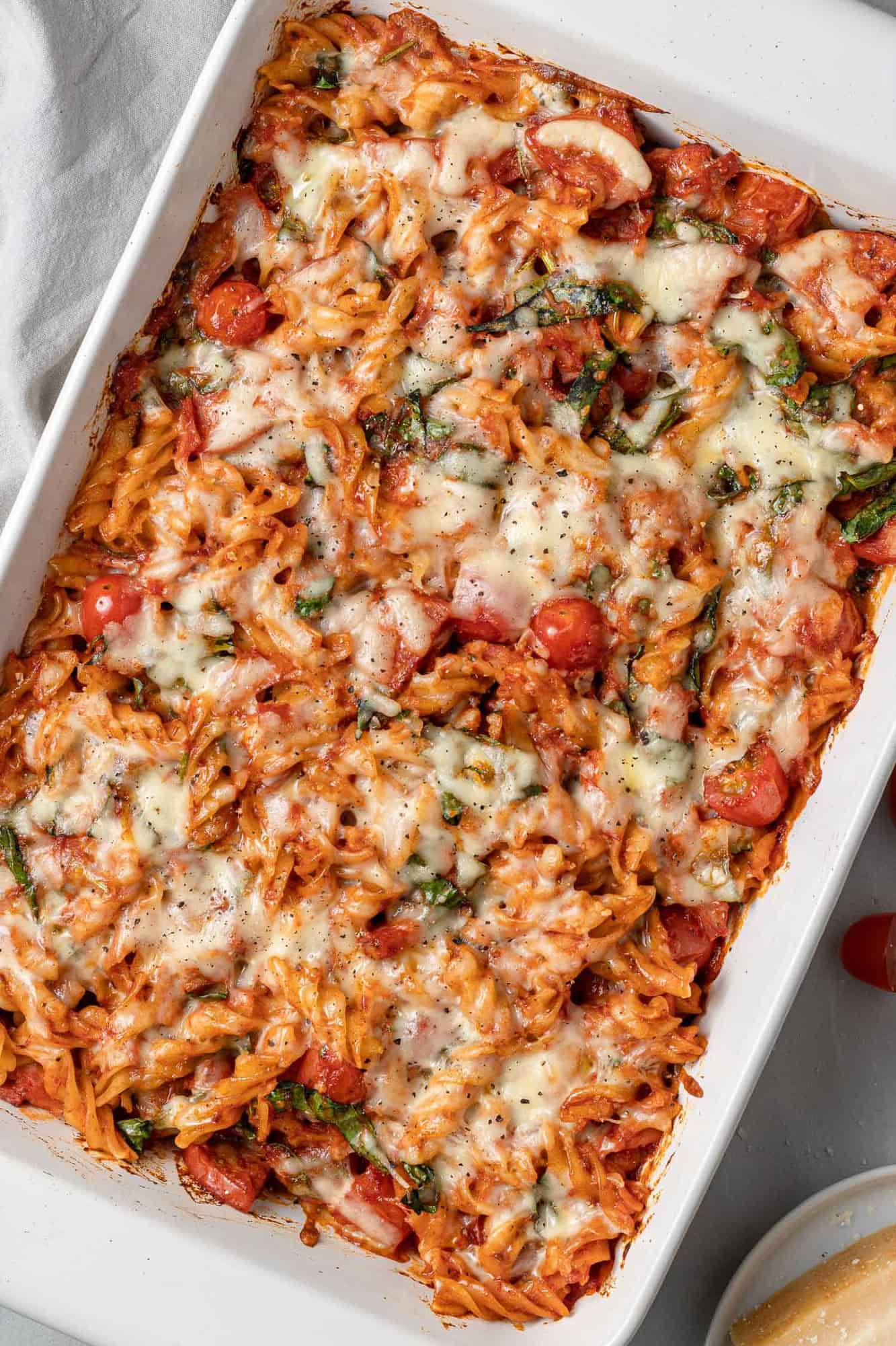 Overhead view of pizza baked pasta in a white baking dish.