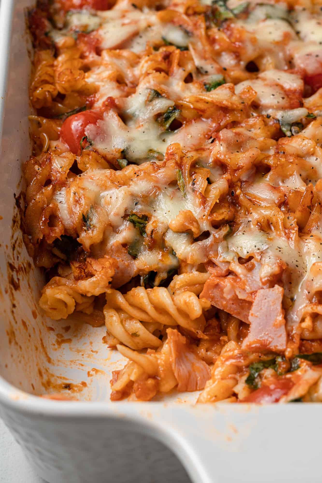 Pasta bake with a scoop taken out to show ingredients.