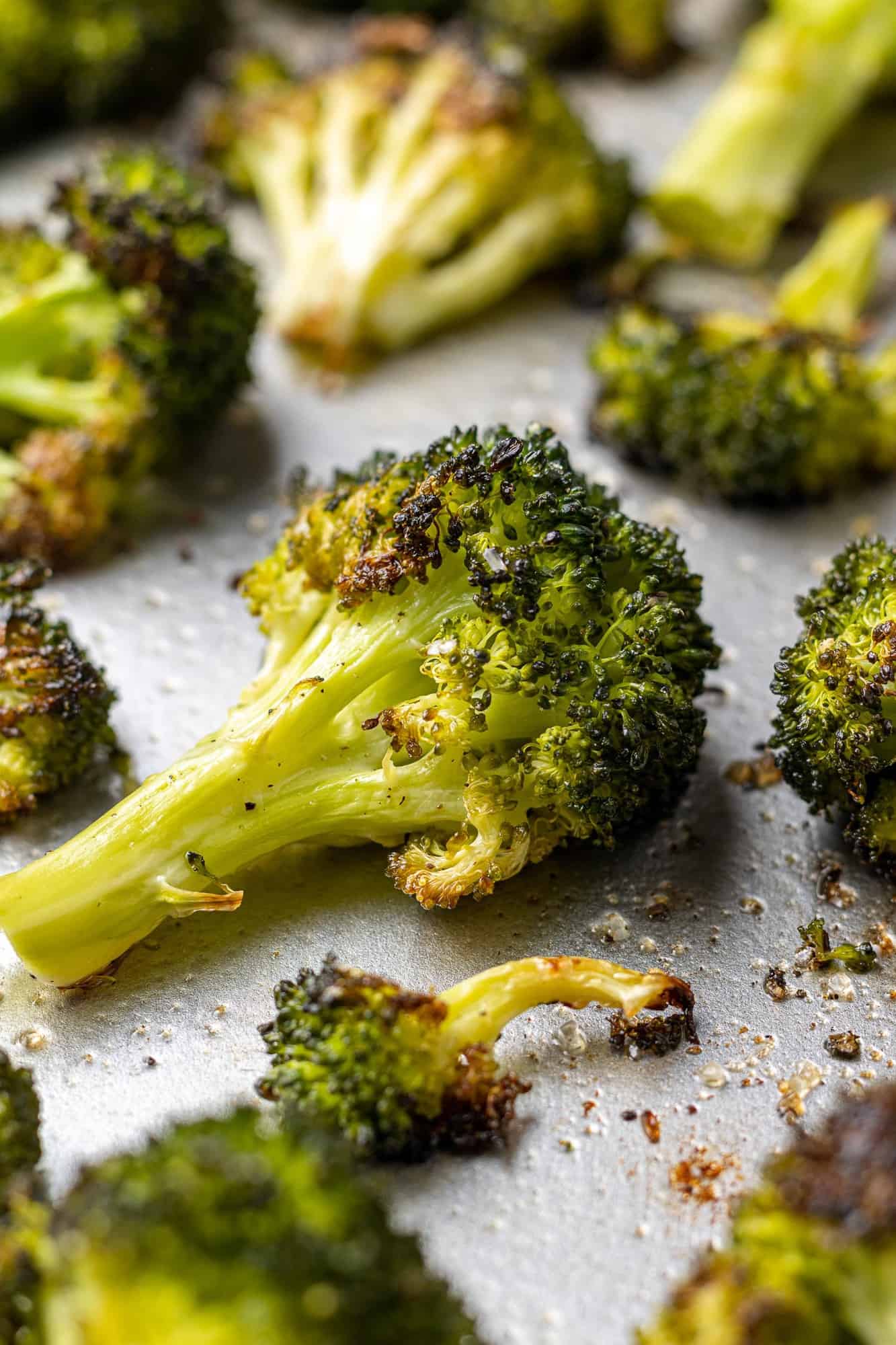 Bright green crispy roasted broccoli on a sheet pan.