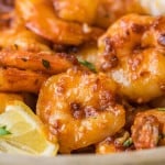 Close-up of cooked prawns with spicy honey sauce and crispy garlic.