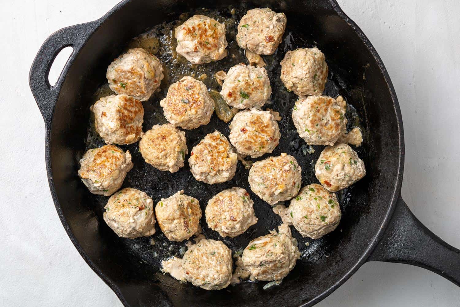 Meatballs in a black cast iron skillet.