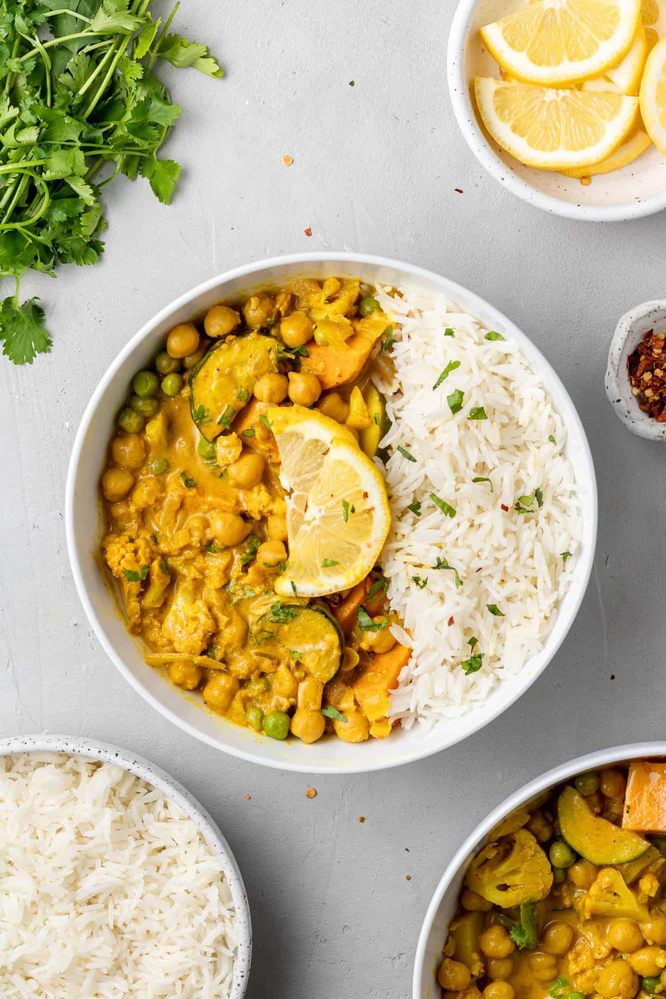 Overhead view of curry in a bowl with rice, sprinkled with cilantro.