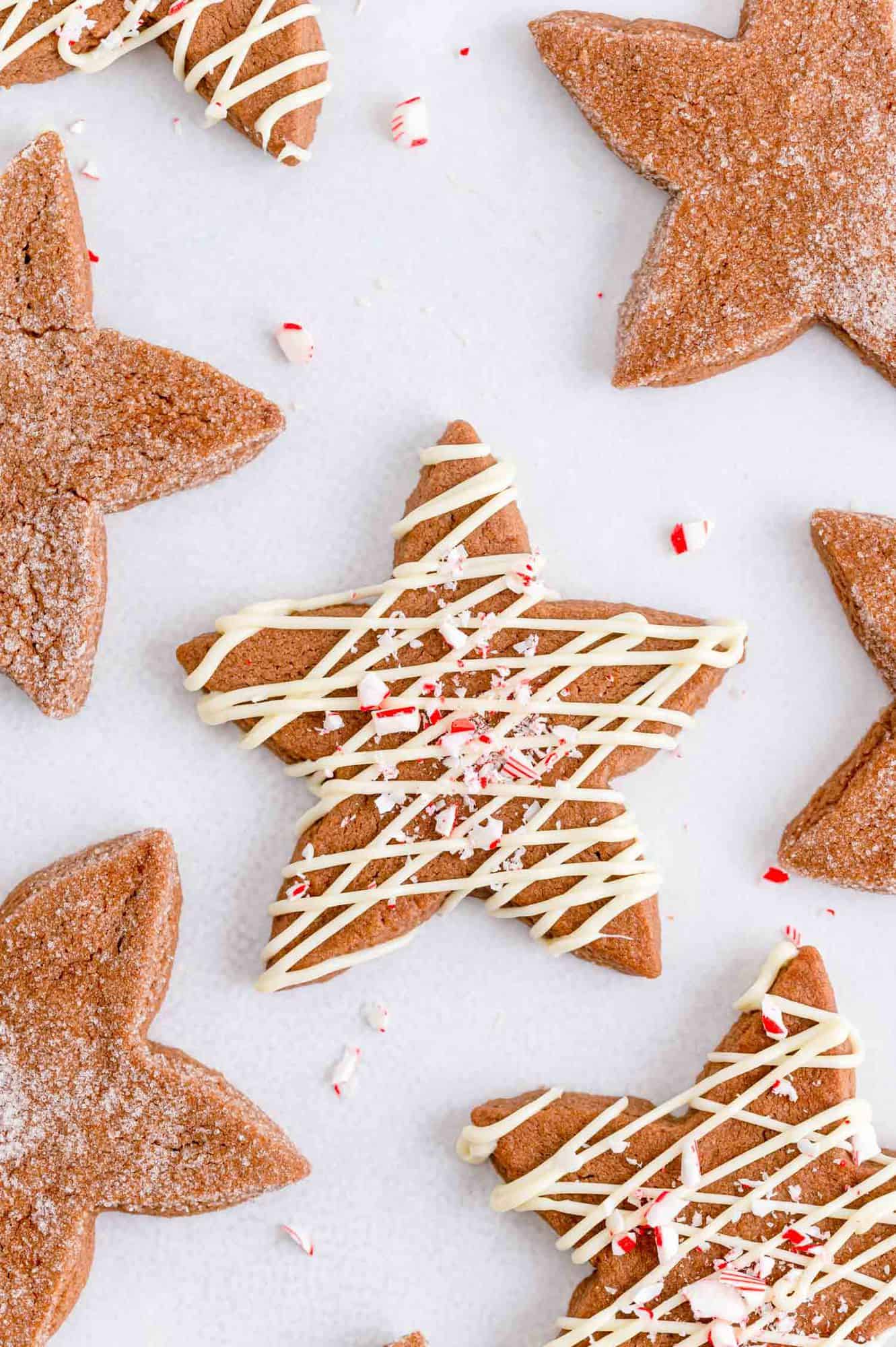 Chocolate peppermint sugar cookies cut into stars, some with white chocolate drizzle.