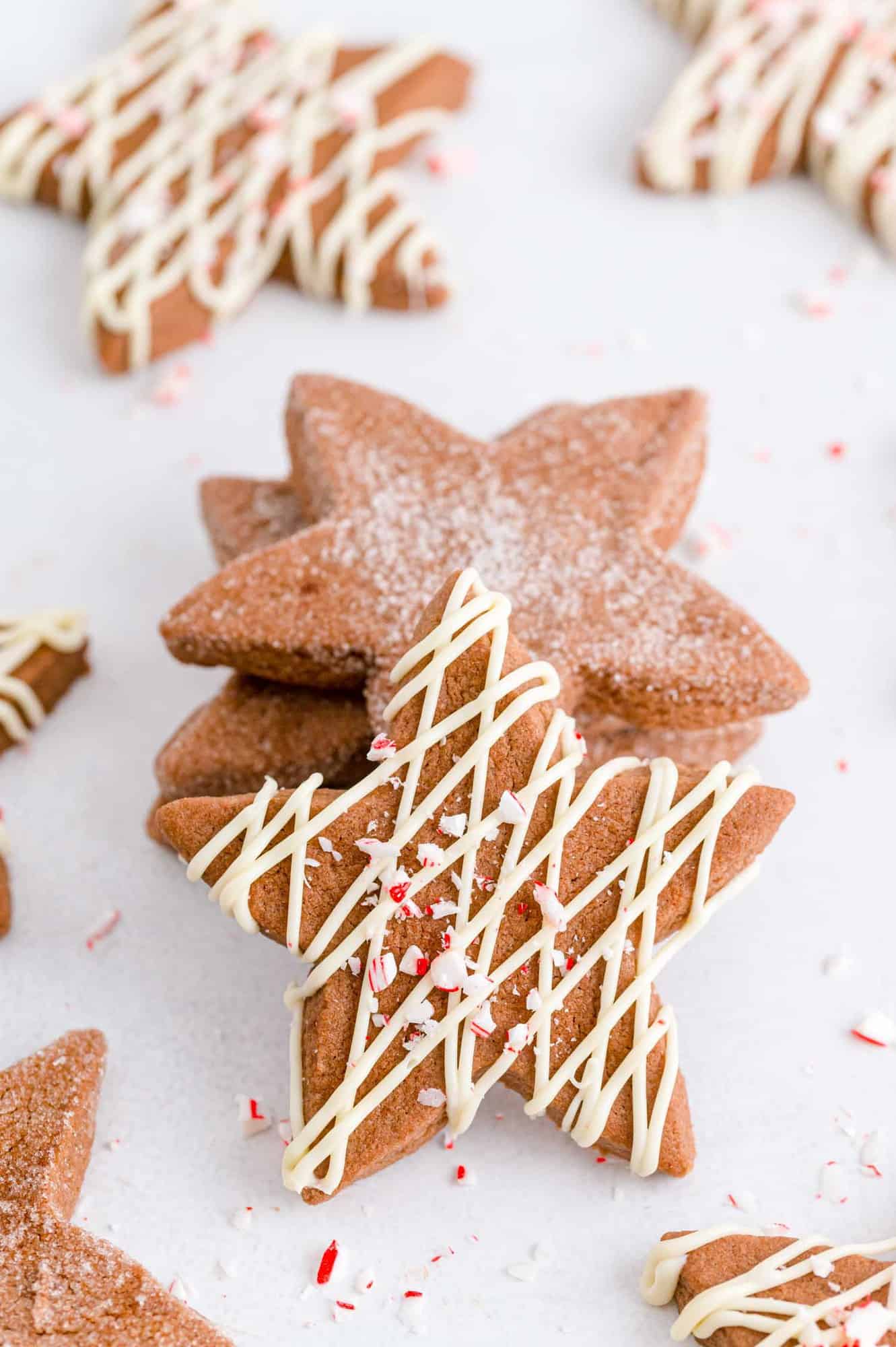 Stack of cookies with one leaning against the front, drizzled with white chocolate.