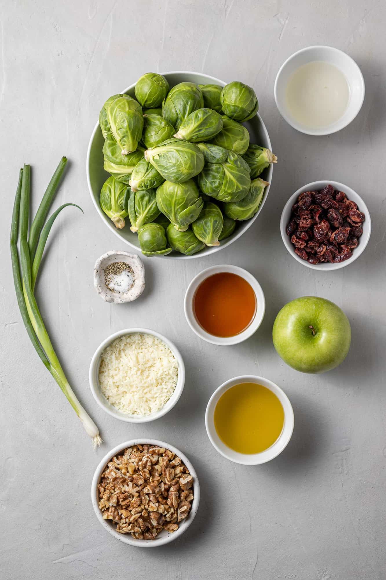 Overhead view of ingredients including brussels sprouts, green onions, walnuts.