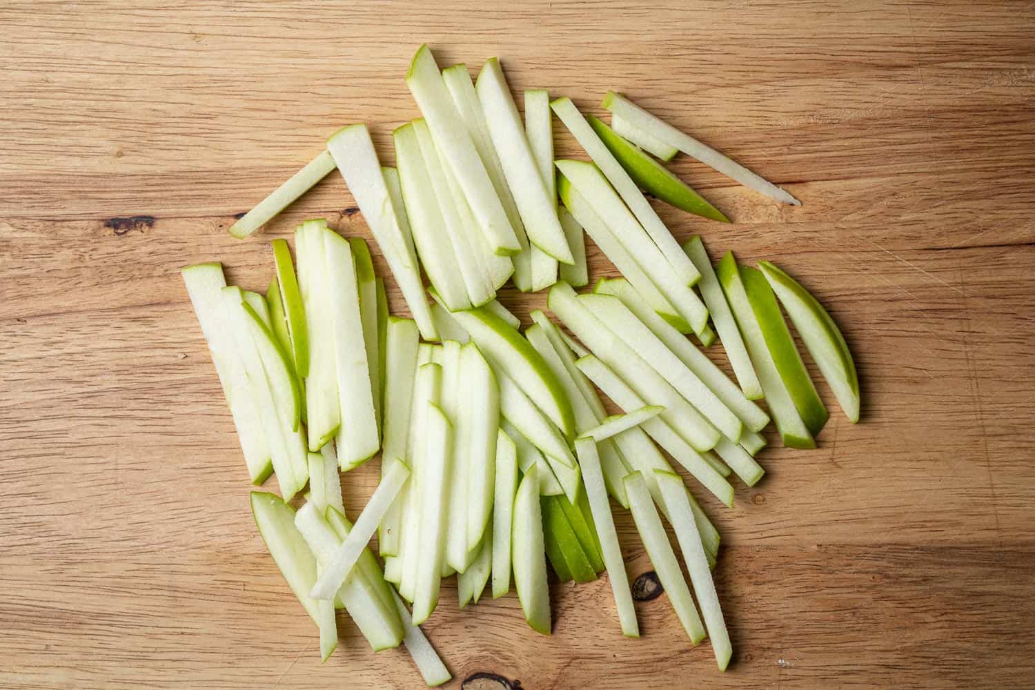 Sliced apples on a wooden cutting board.