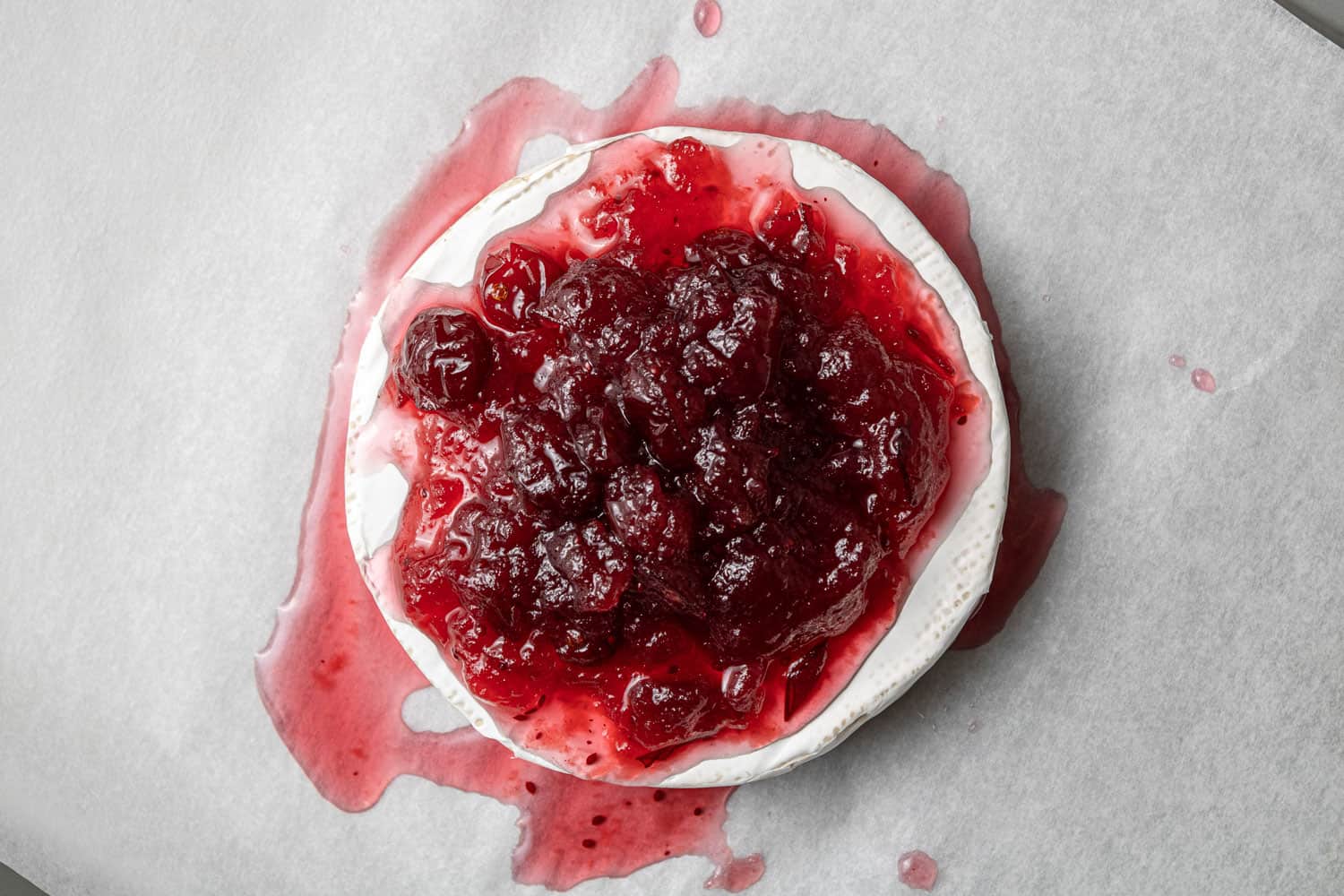 Cranberry sauce on top of a wheel of brie.