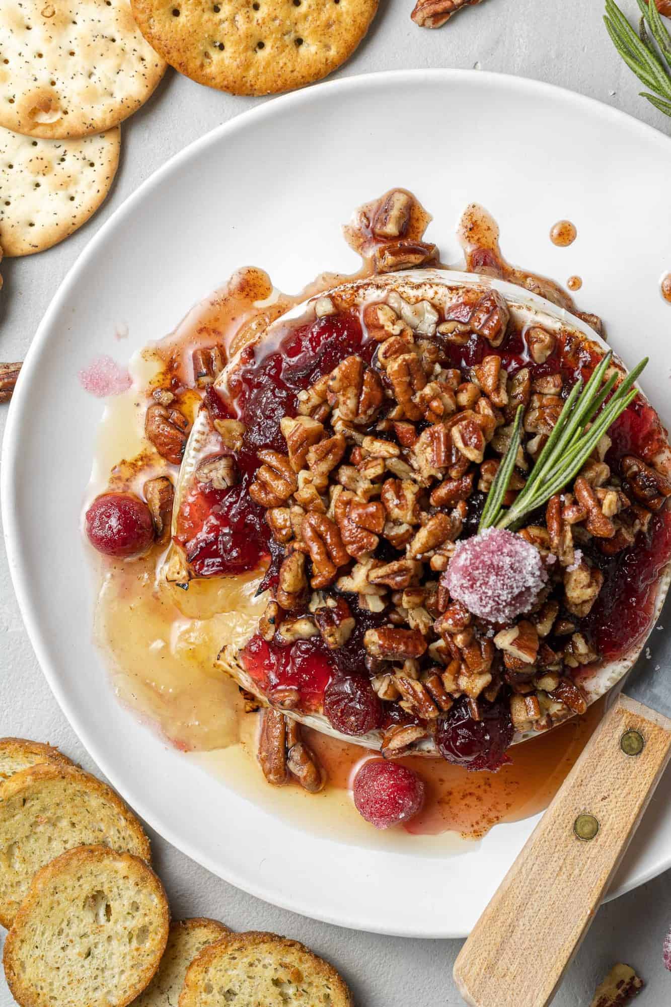 Overhead view of baked brie topped with cranberries and pecans.