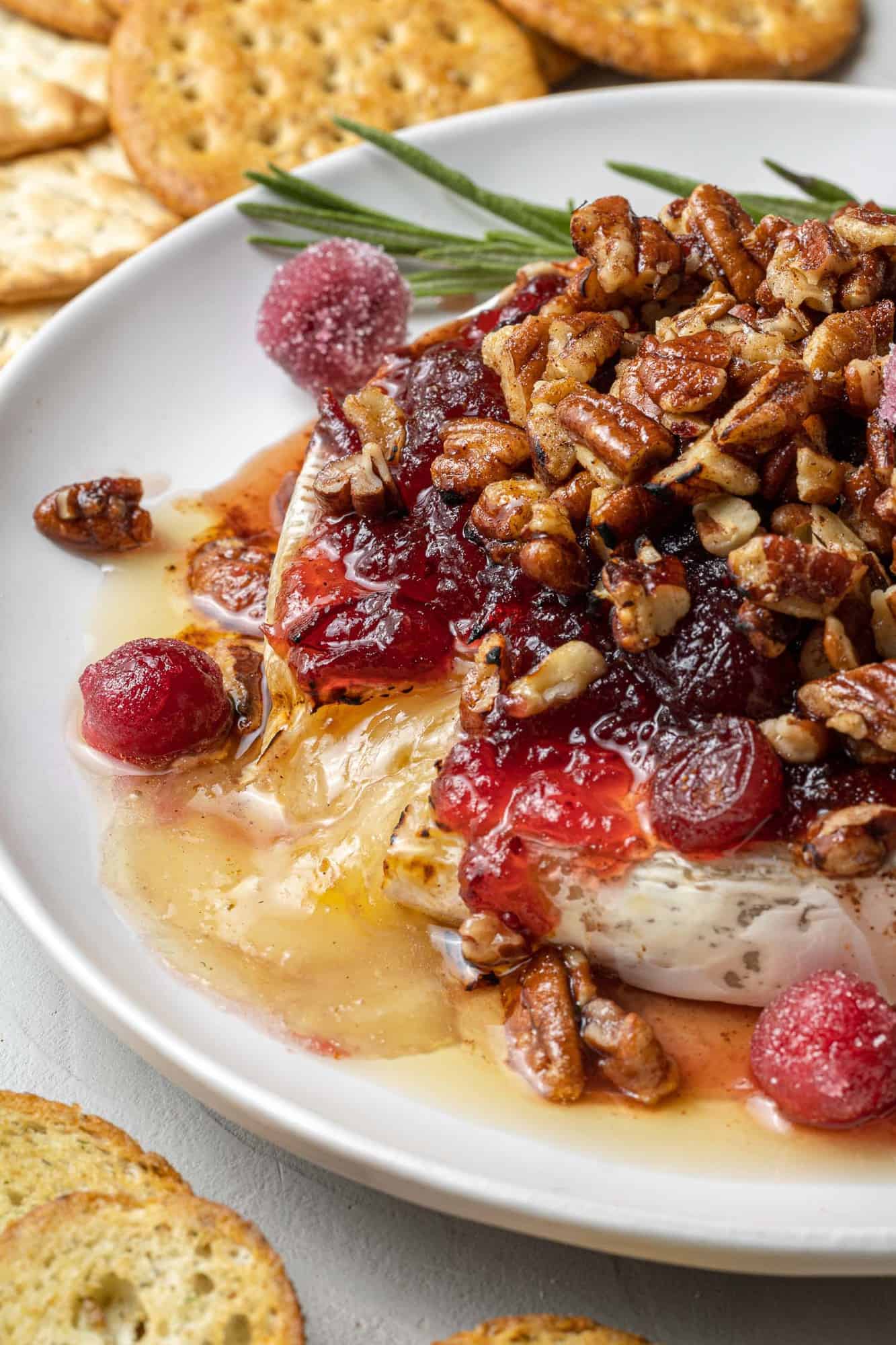 Close up of brie oozing out of a wheel of baked brie.