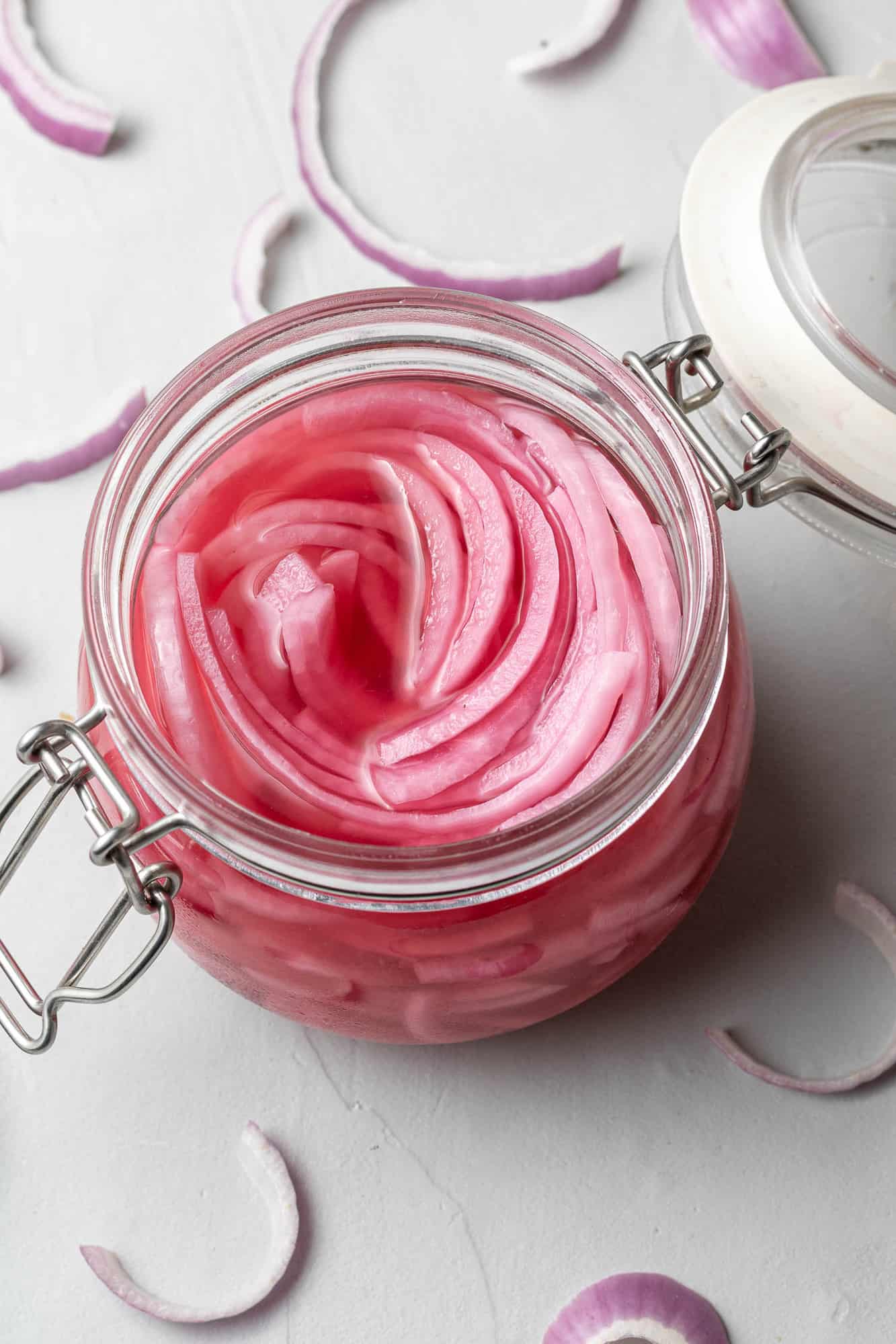 Sliced pickled red onions in a jar.