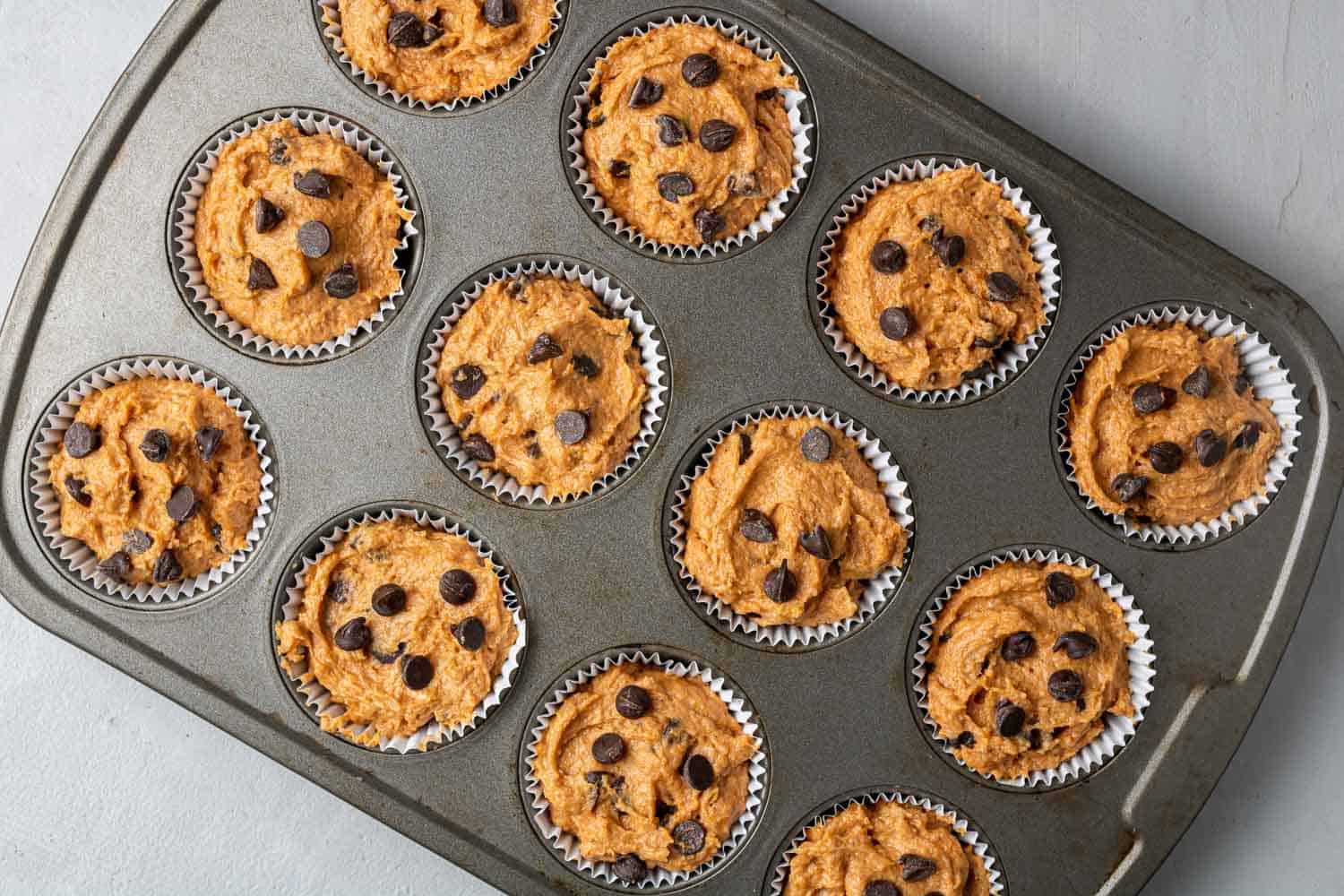 Unbaked muffins in muffin tin.