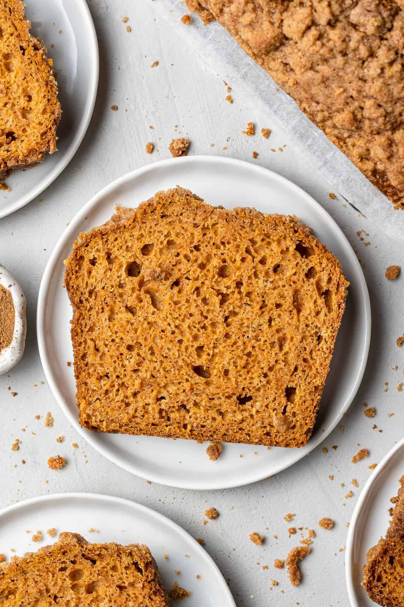 Overhead view of single slice of bread on a small round white plate.