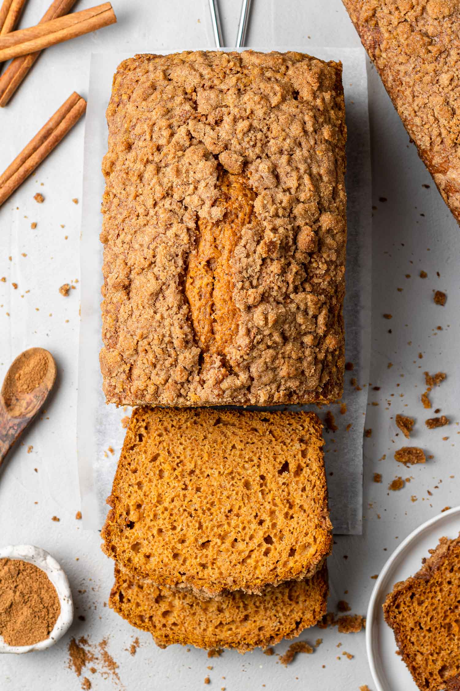 Overhead view of a loaf of pumpkin streusel bread, partially sliced.