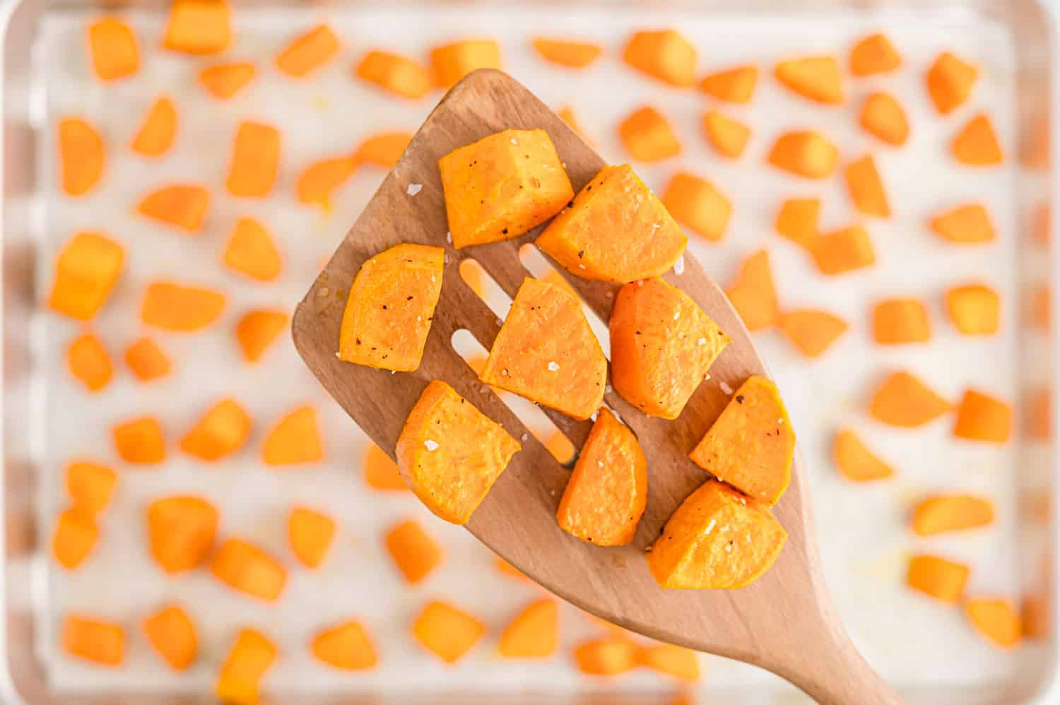 Cooked sweet potatoes on a wooden spatula.