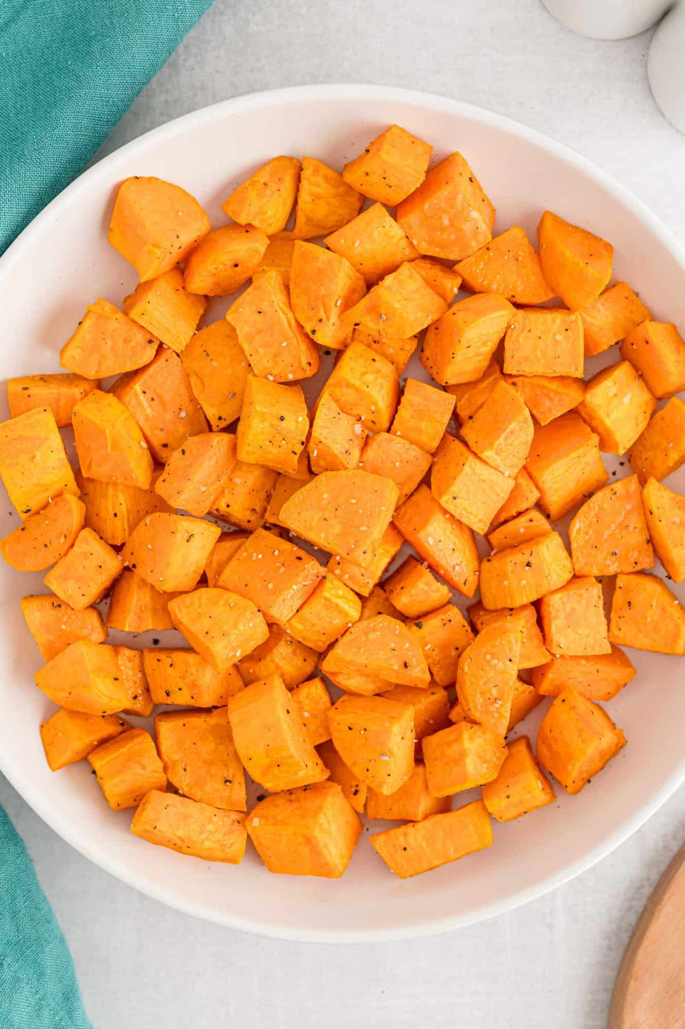 Large white bowl of roasted sweet potatoes.