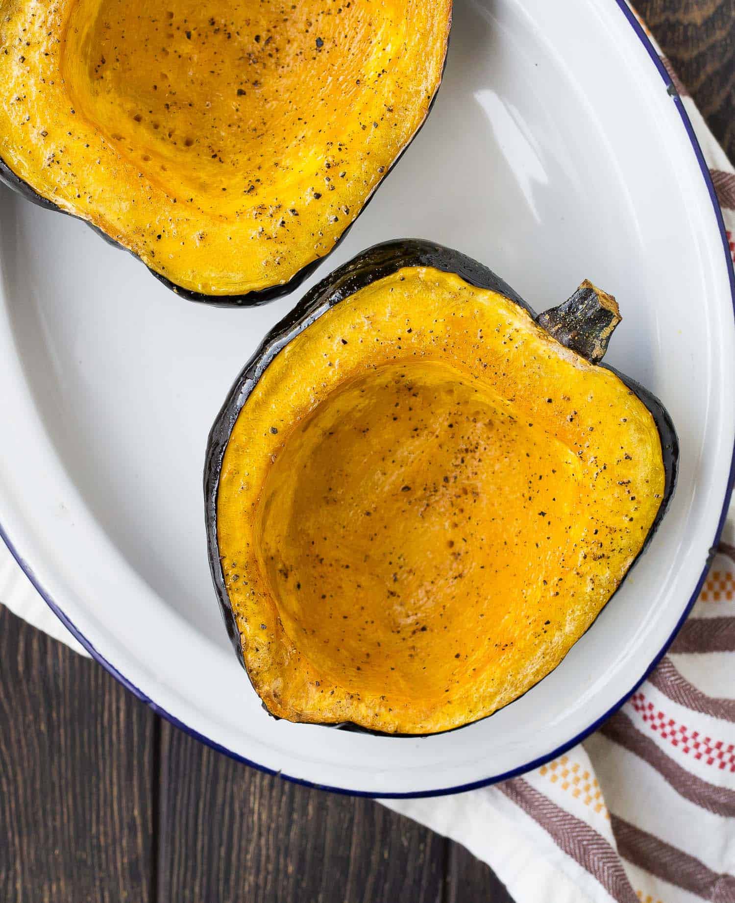 Overhead view of acorn squash half, roasted with pepper.