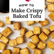 Tofu on a baking sheet, text overly reads "how to make crispy baked tofu."