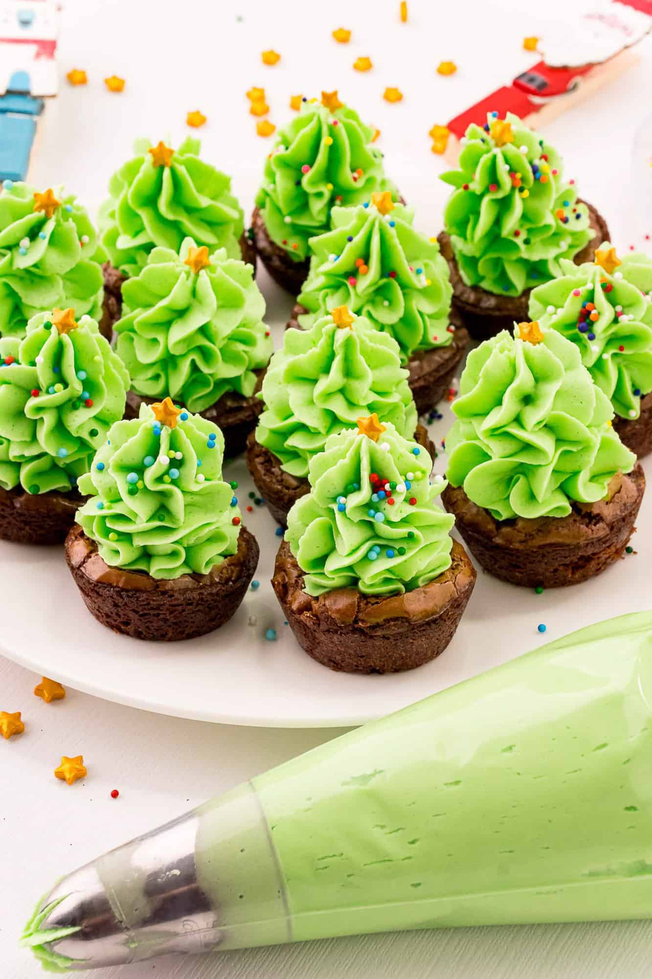 Christmas tree brownies with a piping bag in the front.