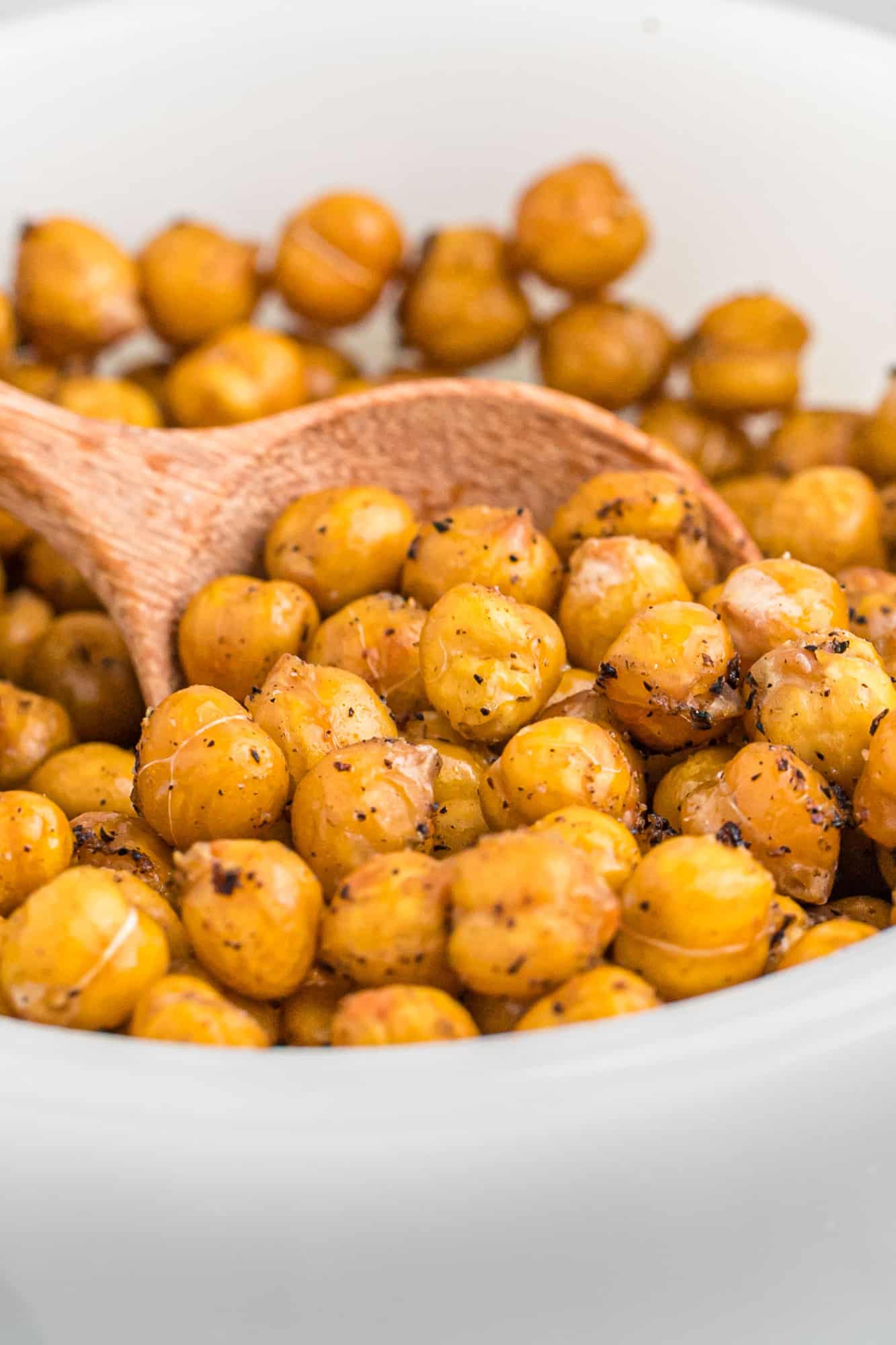 Close up view of crispy chickpeas in a white glass bowl.