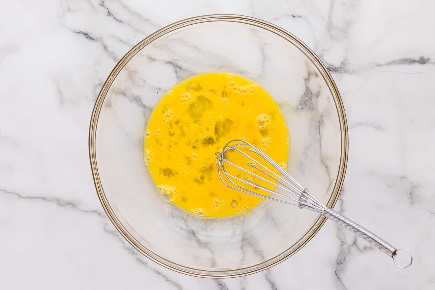 Beaten eggs in a large bowl.