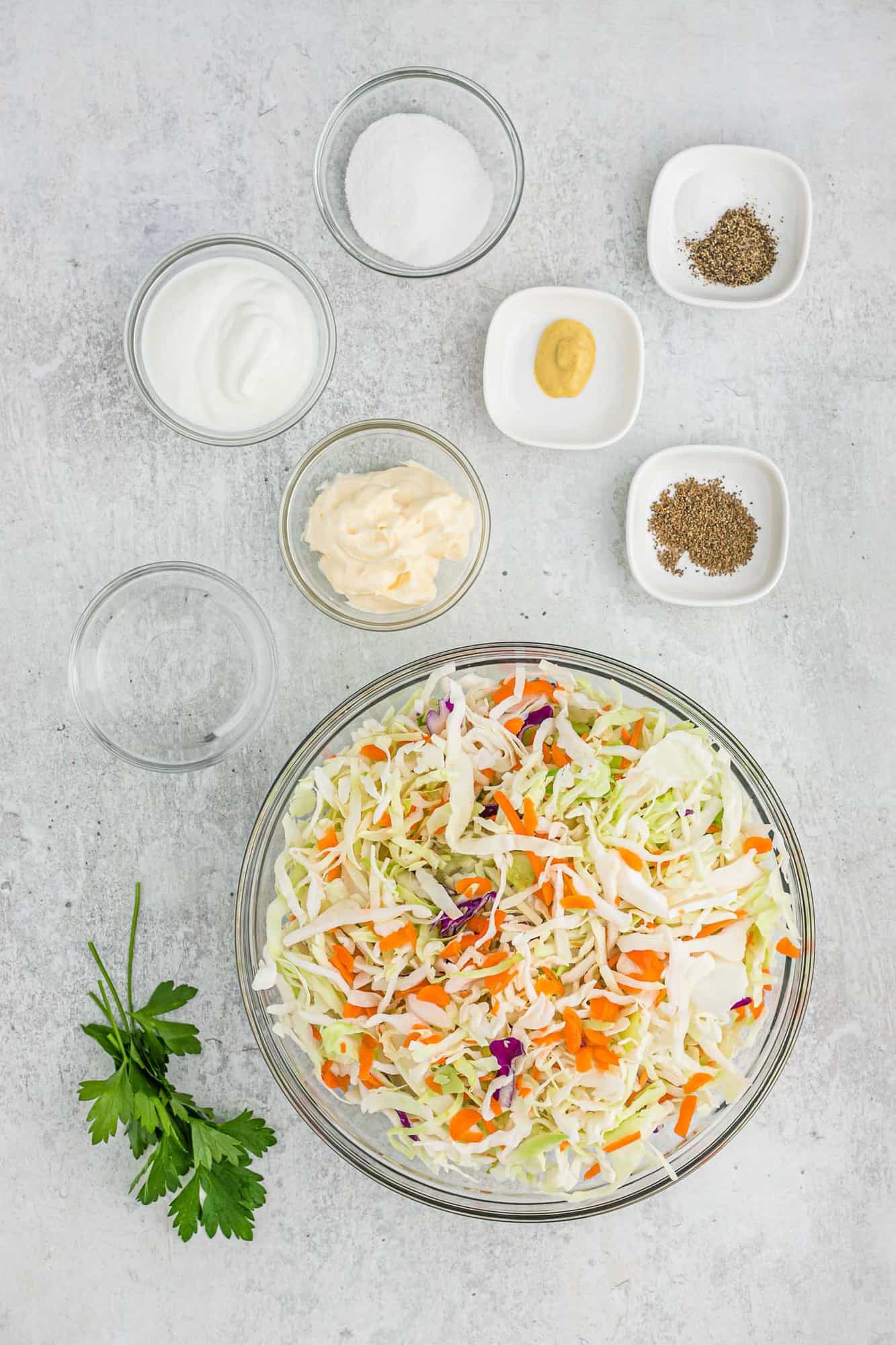 Ingredients in separate bowls, including shredded cabbage and carrots.