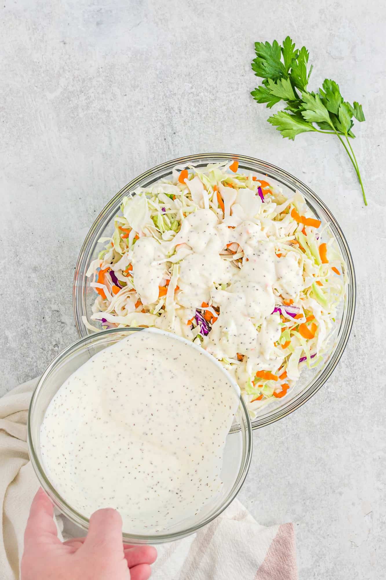 Dressing being poured onto coleslaw.