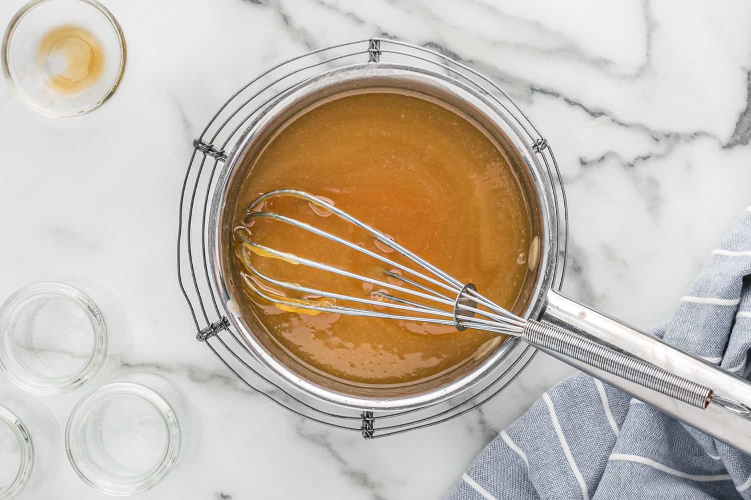 Caramel in a saucepan with a whisk.