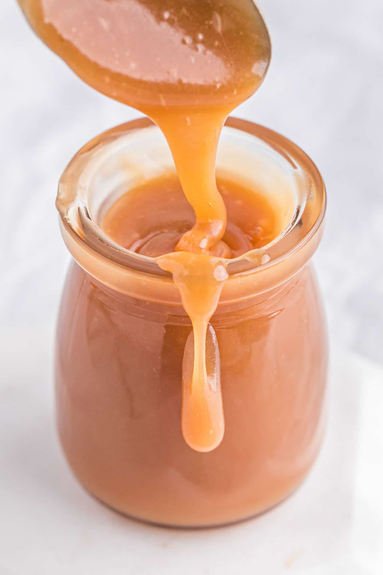 Caramel dripping over the side of a jar.