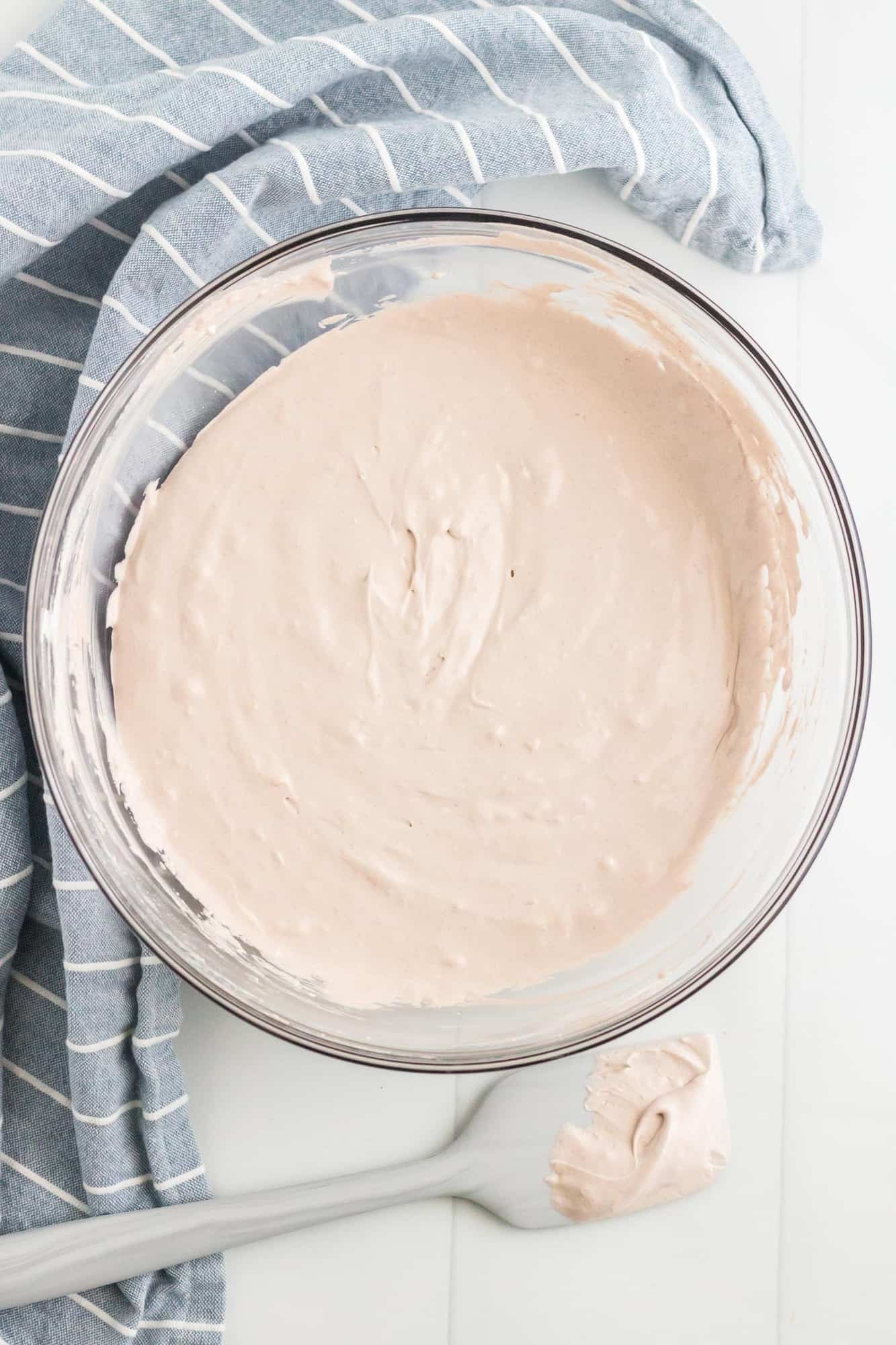 Light brown marshmallow based dip in a clear mixing bowl.