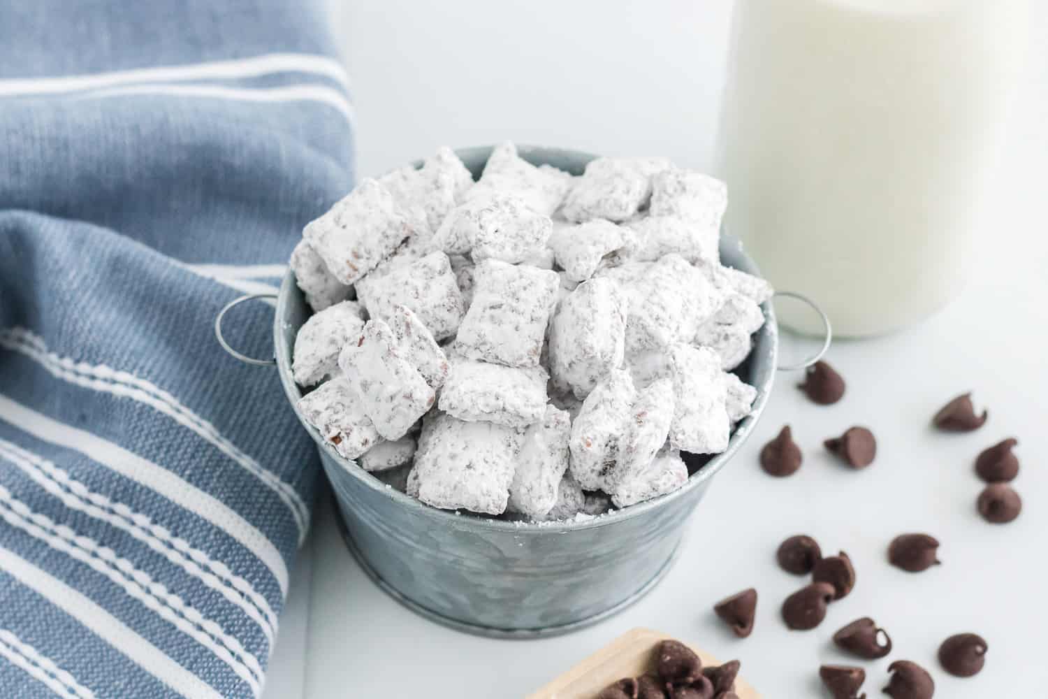 Muddy buddies in a small metal tin, milk in background.