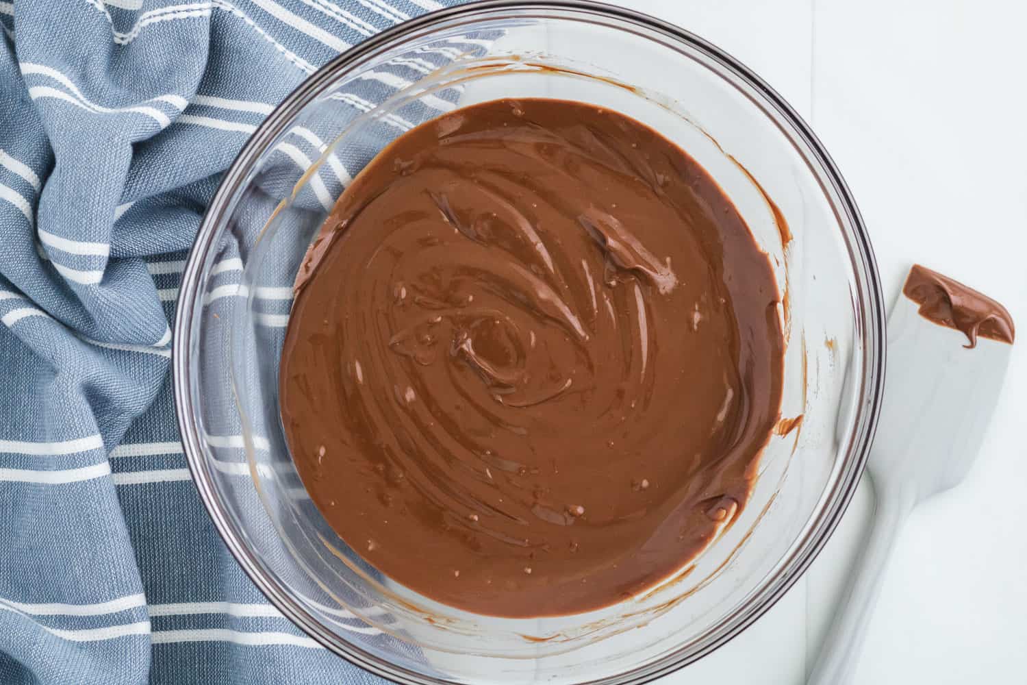 Melted chocolate and peanut butter in a clear glass bowl.