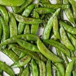 Close up view of sugar snap peas on a pan.