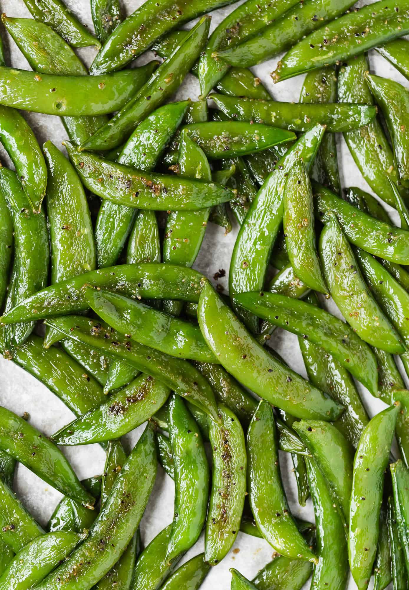 Close up view of sugar snap peas on a pan.