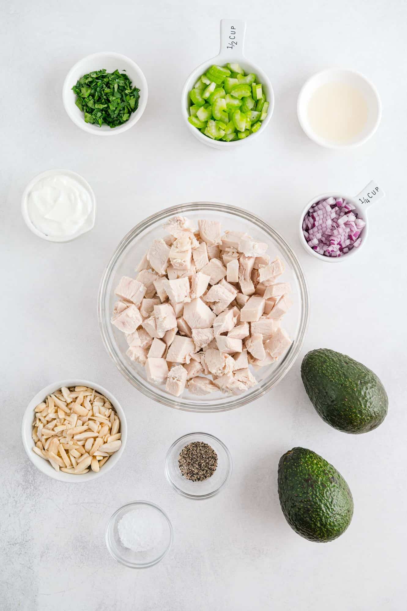 Overhead view of ingredients including cooked chicken and avocados. 