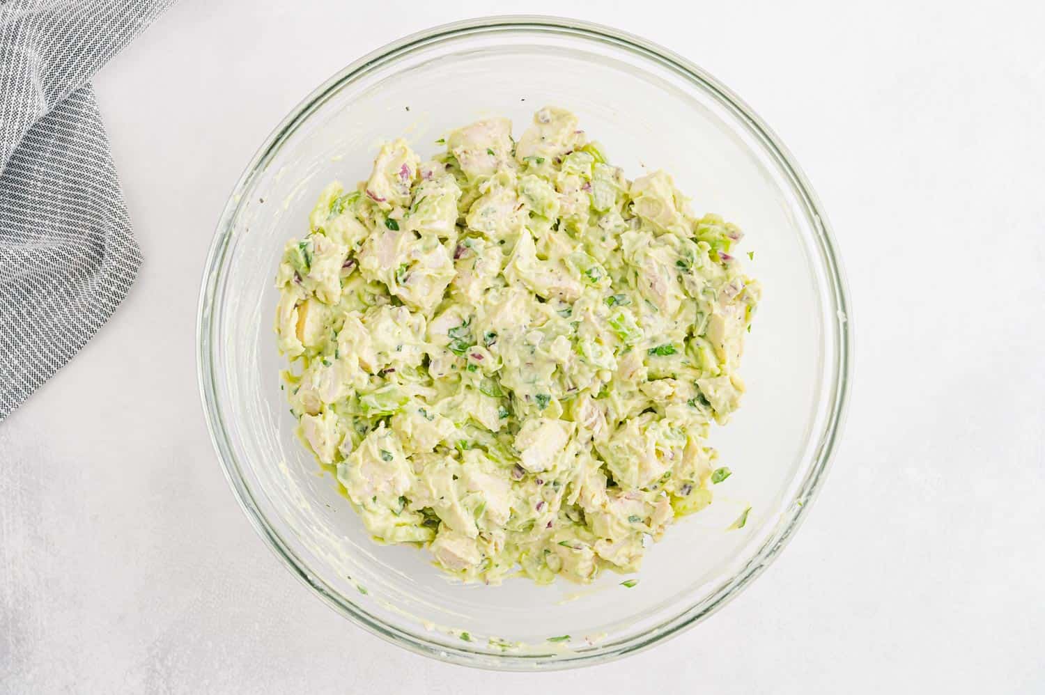 Mixed chicken salad in a glass mixing bowl.