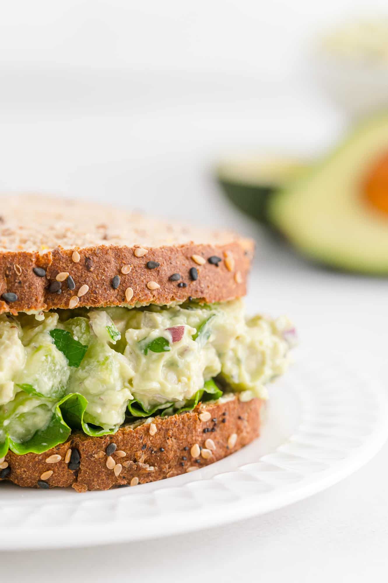 Multigrain bread sandwich with avocado chicken salad and leaf lettuce. 