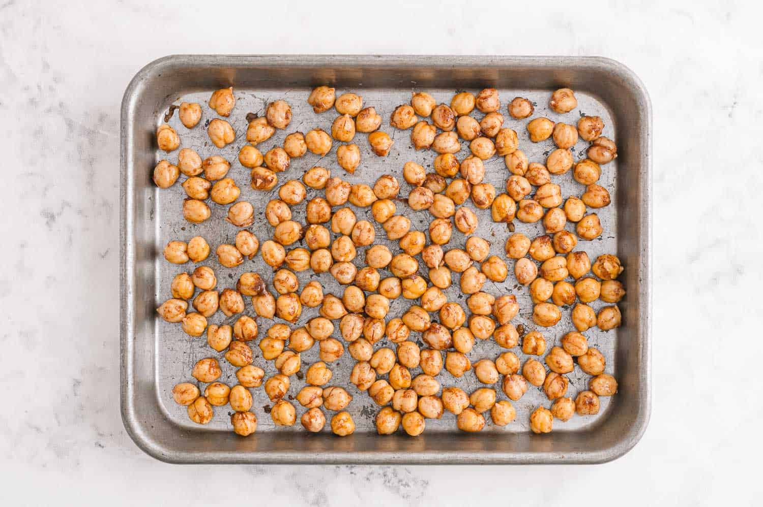 Unbaked chickpeas on a sheet pan.