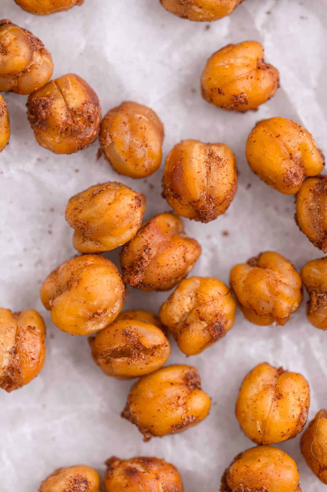 Close up view of roasted chickpeas on parchment paper.
