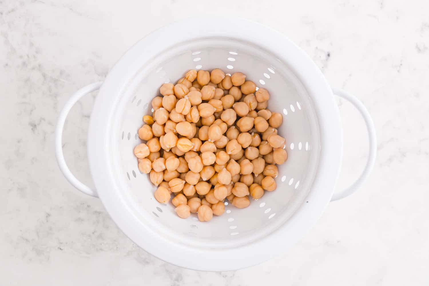 Chickpeas in a white strainer..