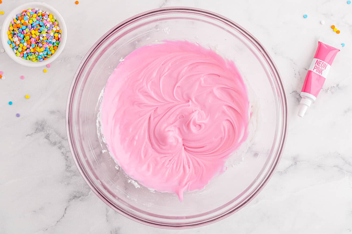 Pink frosting in a bowl.