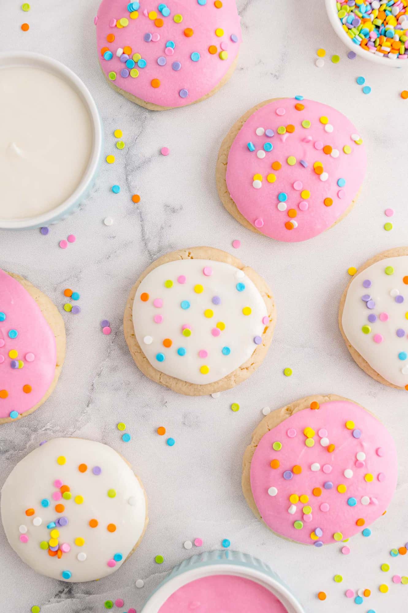 Overhead view of pink and white lofthouse style cookies with colorful sprinkles.