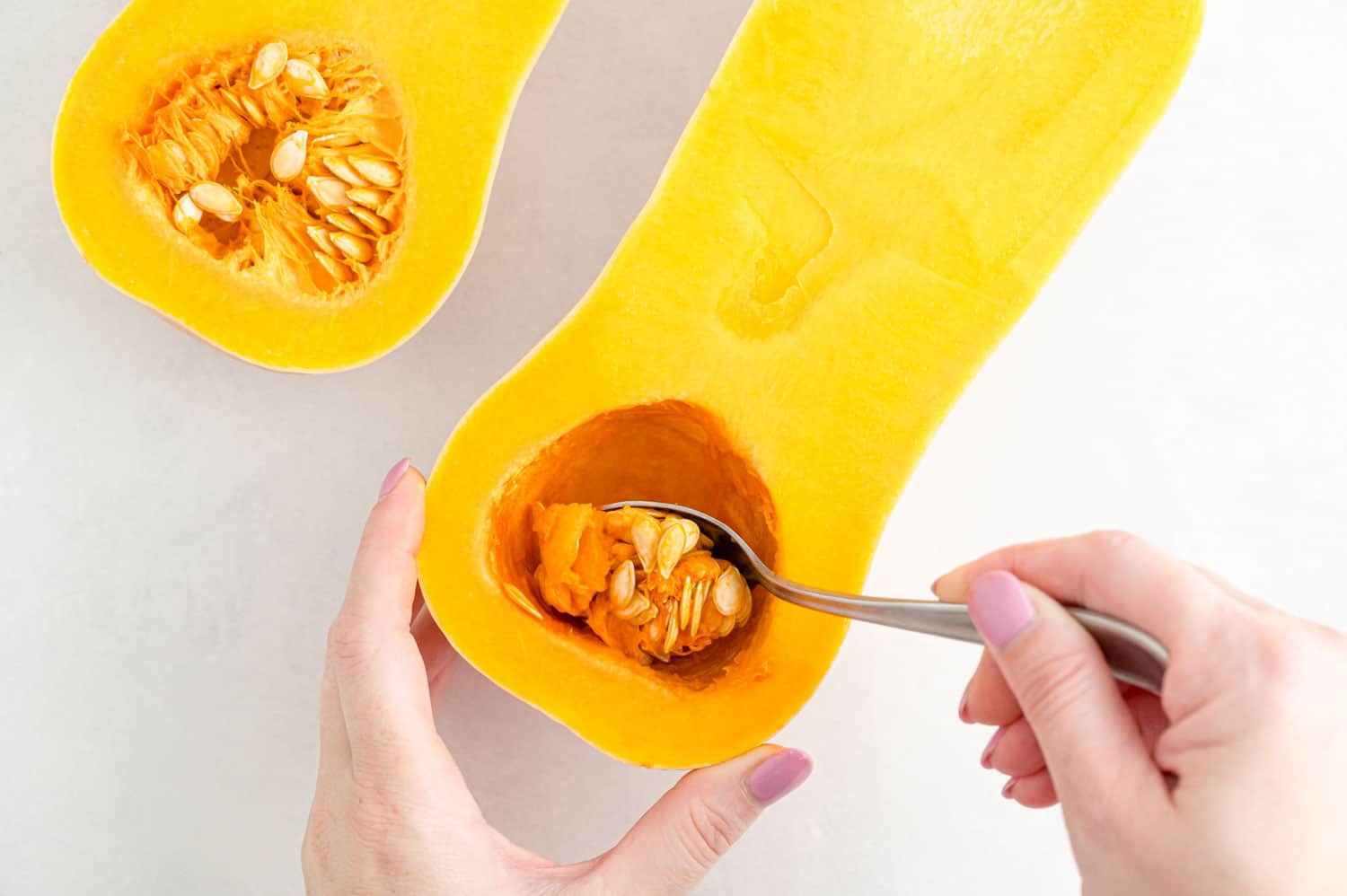 Seeds being scooped out of squash.