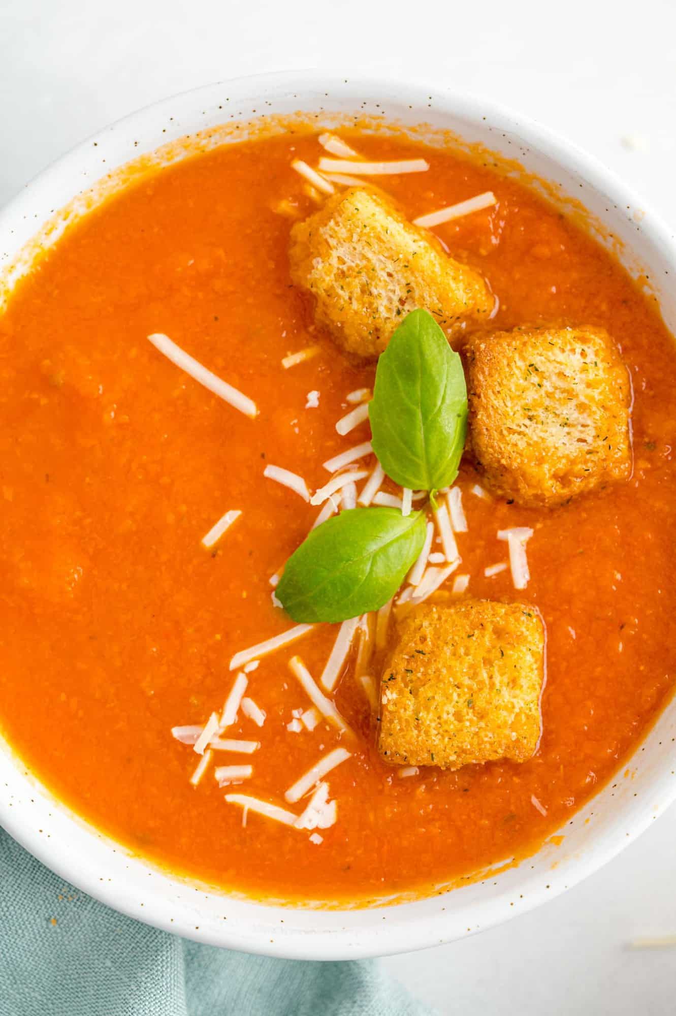 Tomato soup garnished with basil and croutons.