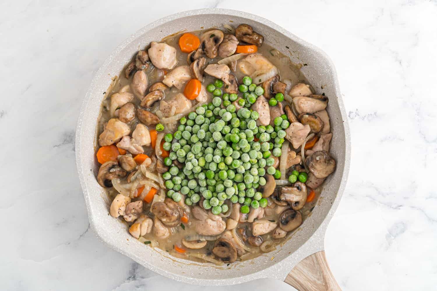 Frozen peas added to pan.