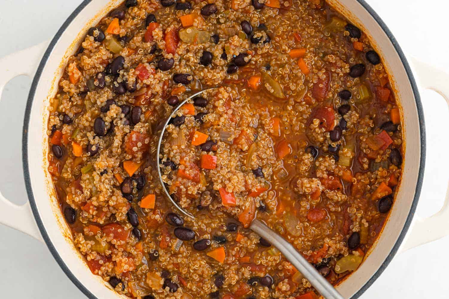 Quinoa in a large pot with a ladle.