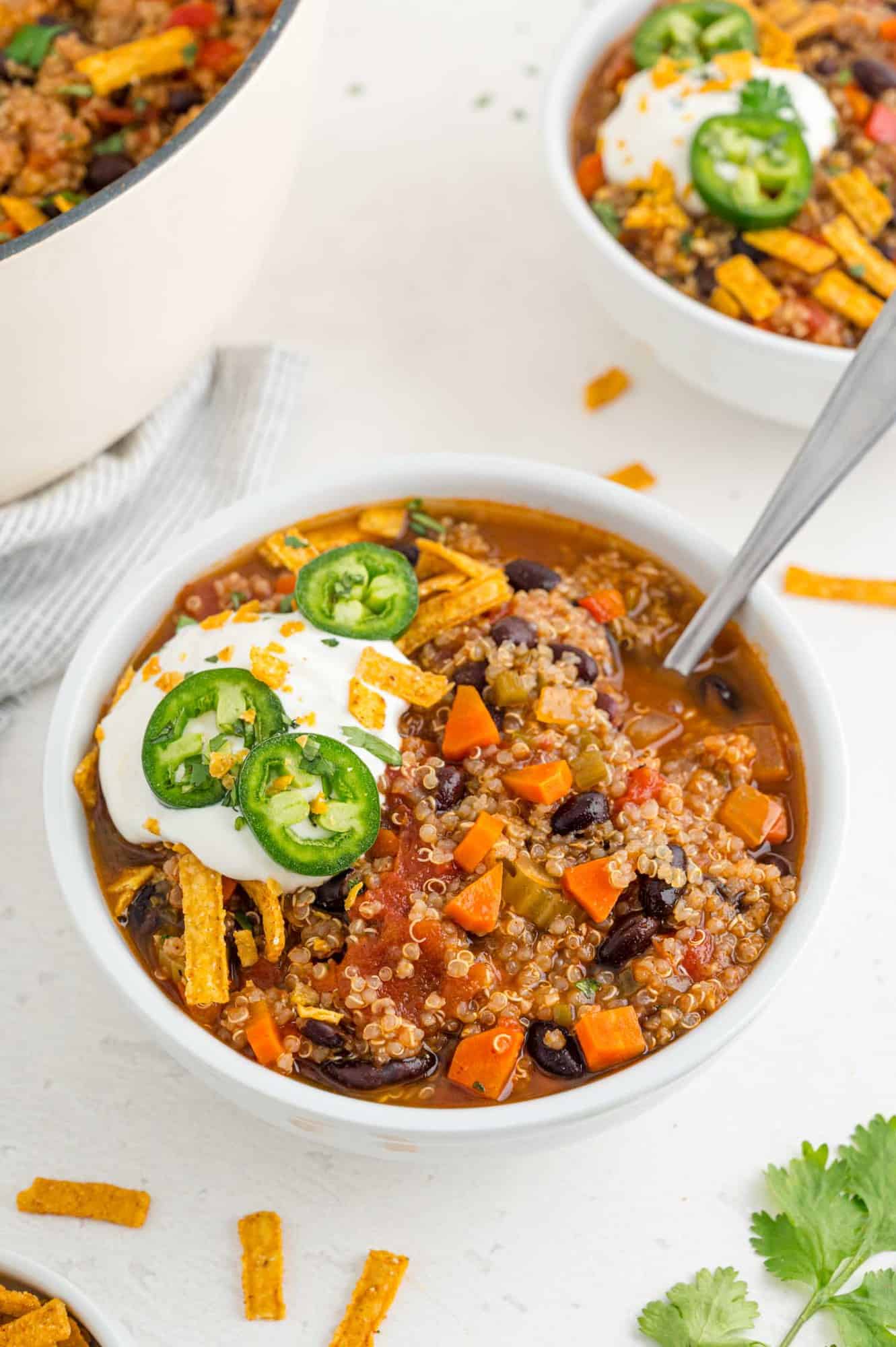 Chili with toppings in a white bowl.