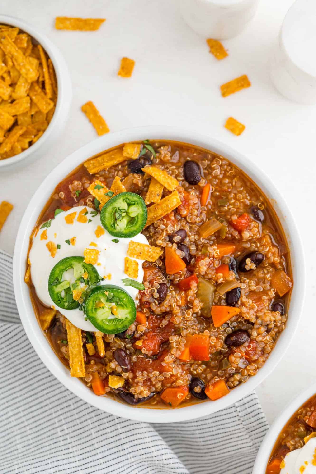 Bowl of quinoa chili with sour cream and jalapeno.