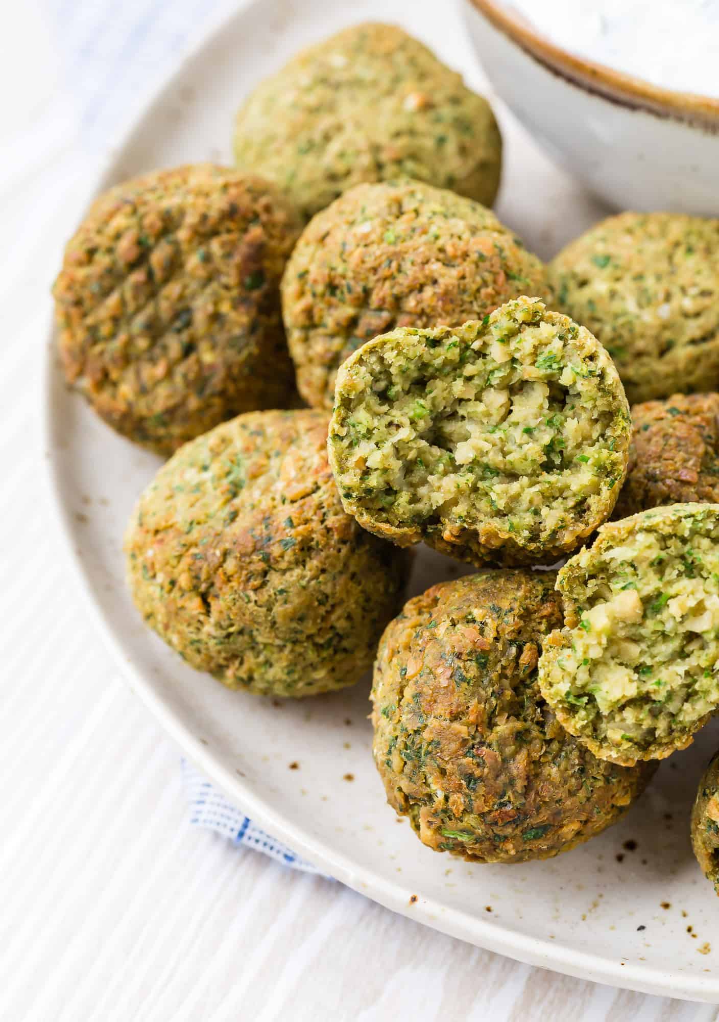 Split-open chickpea fritter made in the air fryer. Flecks of herbs are visible.