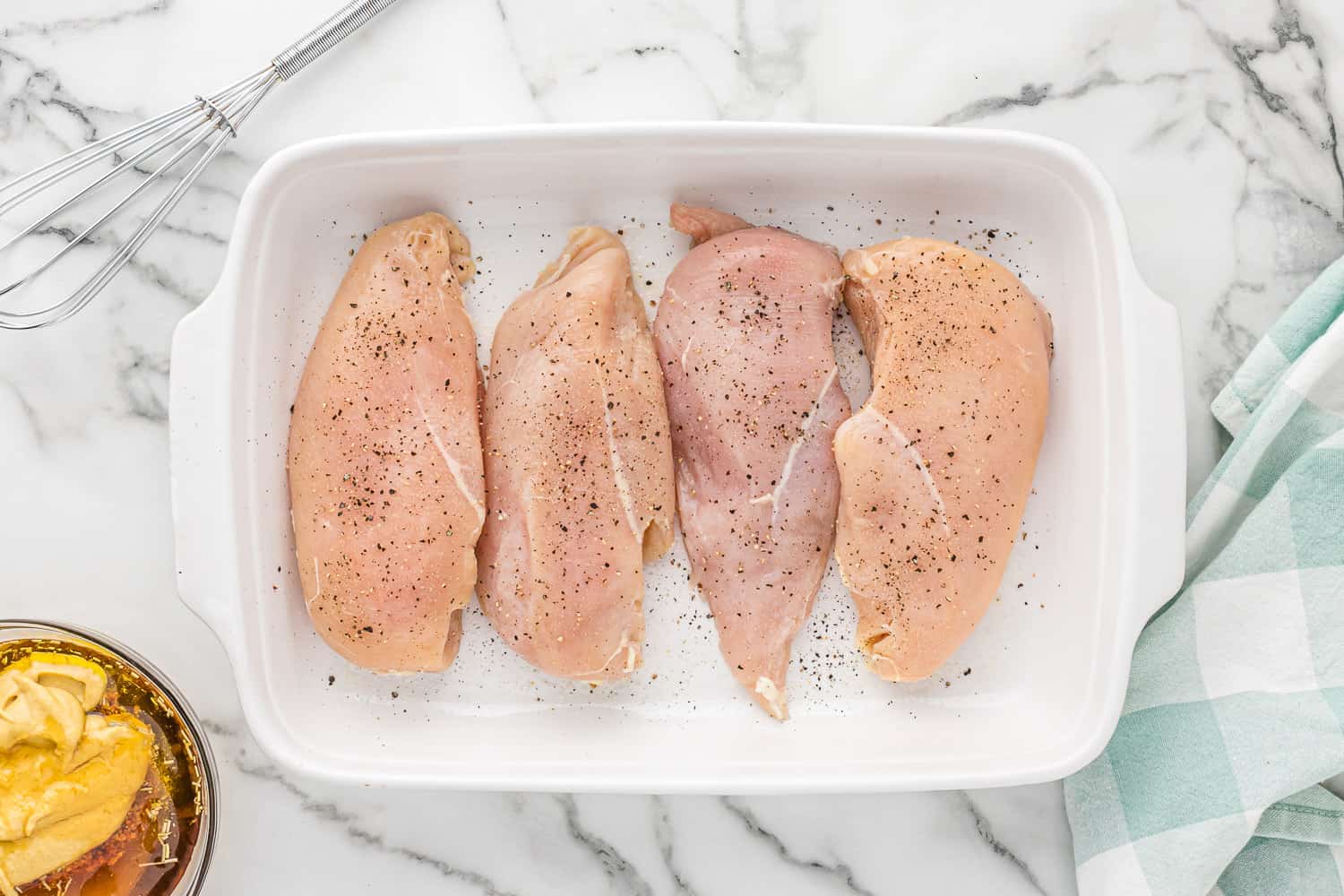Raw chicken seasoned with salt and pepper.